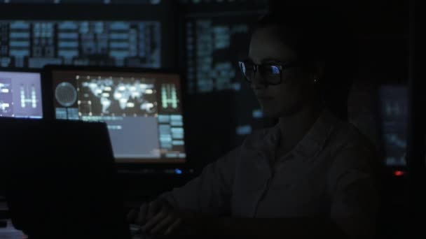 채워진 데이터 센터에 있는 컴퓨터에서 작업 하는 젊은 여자 프로그래머의 디스플레이 스크린 — 비디오