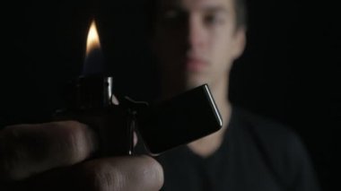 Açılış adam ve demir Zippo siyah bir arka plan üzerinde hafif yanma kapatın