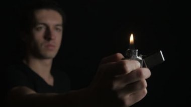 Açılış adam ve demir Zippo siyah bir arka plan üzerinde hafif yanma kapatın
