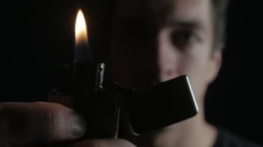 Açılış adam ve demir Zippo siyah bir arka plan üzerinde hafif yanma kapatın