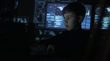 Genç dahi çocuk hacker programcı ile dolu veri merkezi bilgisayara çalışma ekranları görüntülemek. Harika çocuk hacker portresi.