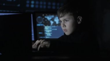 Genç dahi çocuk hacker programcı ile dolu veri merkezi bilgisayara çalışma ekranları görüntülemek. Harika çocuk hacker portresi.