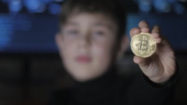 Genç çocuk tutan altın Bitcoin ikili kod arka plan üzerinde. Madencilik ve ticaret — Stok video