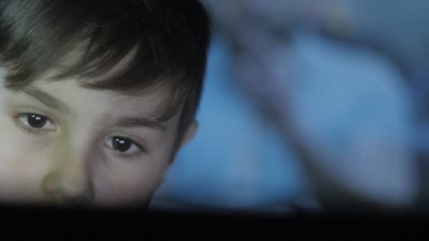 Close-up van Kid afspelen van een video-game op de console. De projectie van het spel op het gezicht en op de muur. Dubbele blootstelling. — Stockvideo