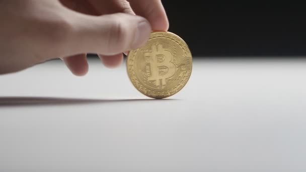 回転テーブルにコイン bitcoin 男の手のクローズ アップ。スローモーション。暗号通貨、電子マネー. — ストック動画