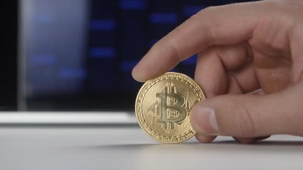 Mains de l'homme tiennent Bitcoin or BTC sur fond de code binaire. mines et commerce — Video