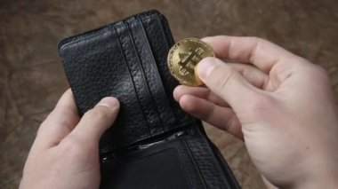 Erkek eli bitcoin 'i tutuyor ve cüzdanına koyuyor. Kripto para kazanma kavramı. Madencilik bitcoin.