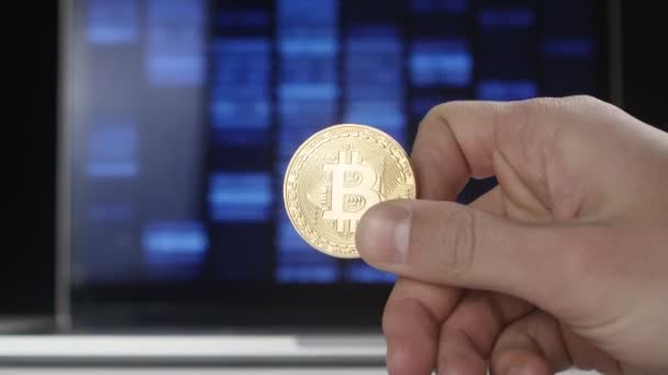 Mains de l'homme tiennent Bitcoin or BTC sur fond de code binaire. mines et commerce — Video