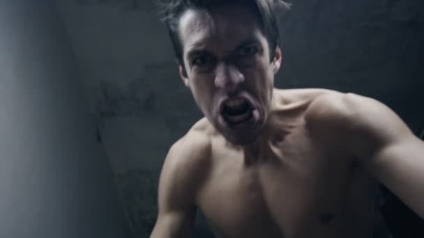 Woedend agressieve man slaat met zijn vuisten de liggende persoon — Stockvideo