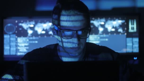 Hacker programozó szemüveg van működő-ra számítógép, a számítógépes biztonsági központ tele van bemutatás ernyőz. — Stock videók