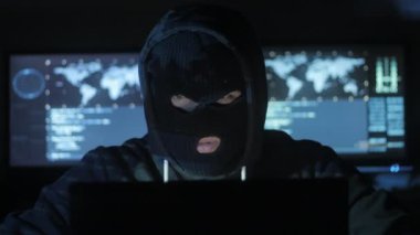 Maskeli tehlikeli hacker sistemi güvenlik şifresini bulmak için kodları ve numaraları kullanarak girmek için çalışır. Siber Suçlar kavramı.