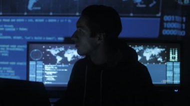 Genç Geek Hacker yazılımcı göstermek perde ile dolu siber güvenlik Merkezi'ndeki bilgisayarda çalışan.