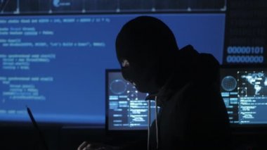 Maskeli tehlikeli hacker sistemi güvenlik şifresini bulmak için kodları ve numaraları kullanarak girmek için çalışır. Siber Suçlar kavramı.