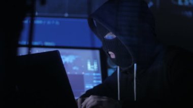 Maskeli anonim hacker sistemi güvenlik şifresini bulmak için kodları ve numaraları kullanarak girmek için çalışır. Siber Suçlar kavramı.