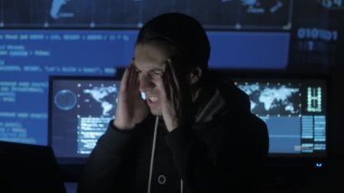 Erkek geek hacker bilgisayar başında overworking ve Siber Güvenlik Merkezi göstermek perde ile dolu bir baş ağrısı muzdarip.