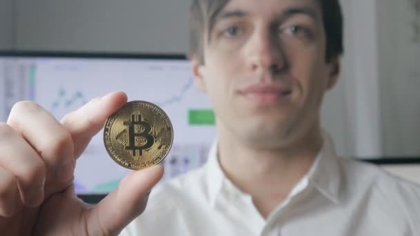 Бізнесмен тримає золото Bitcoin в руці. Інструмент буровій і торгівлі — стокове відео