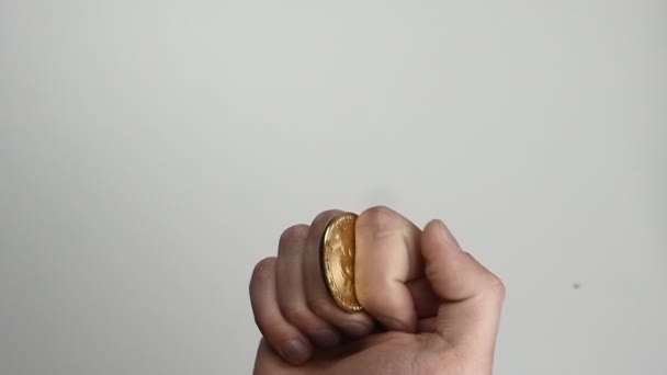 Nära upp mans hand kasta upp mynt av bitcoin Btc i slow motion på isolerade vit bakgrund — Stockvideo