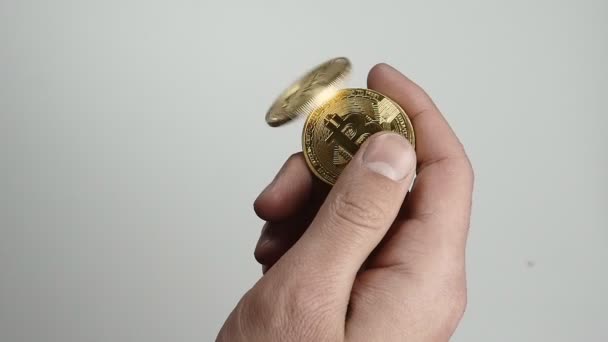 Закрыть руки мужчин бросать монеты биткойна BTC в замедленной съемке на изолированном белом фоне — стоковое видео