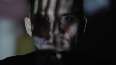 Bir video ya da Tv veya bilgisayar monitörü film izlerken genç bir adam portresi kapatın. Onun yüzünde yansıma