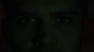 Bir video ya da Tv veya bilgisayar monitörü film izlerken bir genç adamın kapatın. Onun yüzünde yansıma