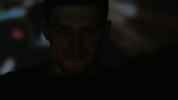 Close up van een jonge man speelt video spel simulator met laptop in de donkere kamer. Dubbele blootstelling van het spel op het gezicht en op de muur. — Stockvideo