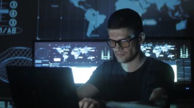 portre ile dolu veri merkezindeki bir bilgisayarda çalışan genç bir programcı görüntüleme ekranları