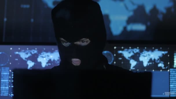 Dangerous hacker in the mask tries to enter the system using codes and numbers to find out the security password. The concept of cybercrime. — Stock Video