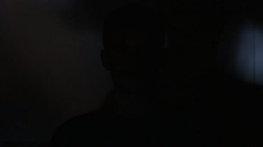 Genç adam bir video ya da Tv veya bilgisayar monitörü film izlerken portresi. Onun yüzünde yansıma