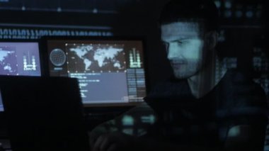 Siber Güvenlik Merkezi'ndeki yüzünde mavi kod karakterlerini yansıtan süre bilgisayar başında çalışan erkek hacker programcı göstermek perde ile dolu.