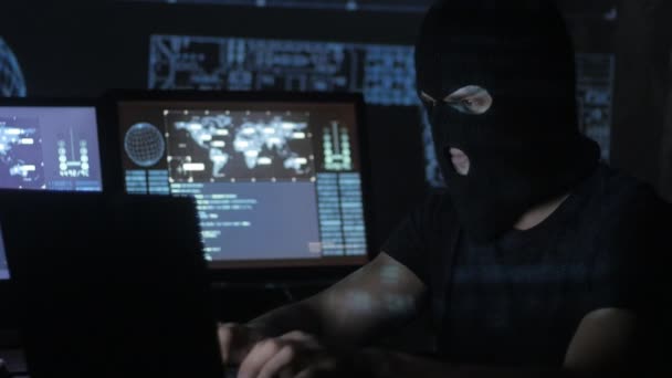 Dangerous hacker in the mask tries to enter the system using codes and numbers to find out the security password. The concept of cybercrime. — Stock Video