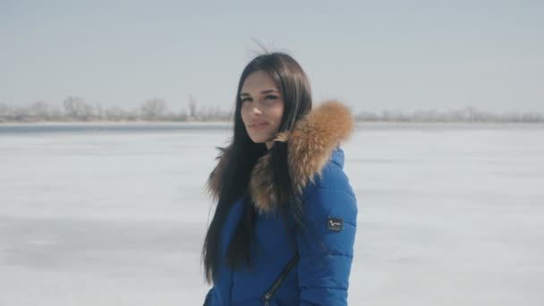Πορτρέτο του μελαχρινή νεαρή όμορφη γυναίκα το χειμώνα σε ένα φόντο του χιονιού — Αρχείο Βίντεο