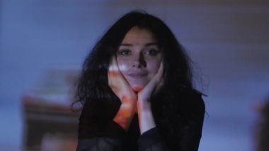 bir video ya da Tv veya bilgisayar monitörü film izlerken bir genç kadının portresi. Yansıma yüzünde