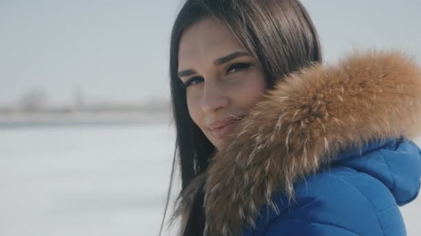 Retrato de joven hermosa mujer morena en invierno sobre un fondo de nieve — Vídeos de Stock