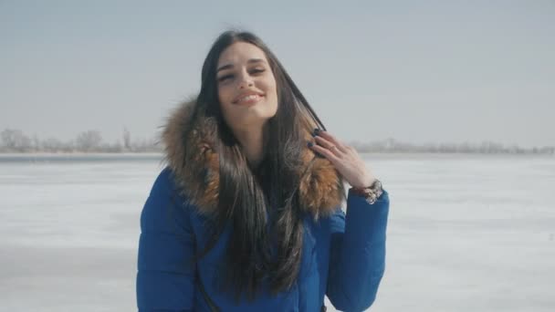 Portret van jonge mooie mooie brunette vrouw die lacht bij winter besneeuwde achtergrond — Stockvideo