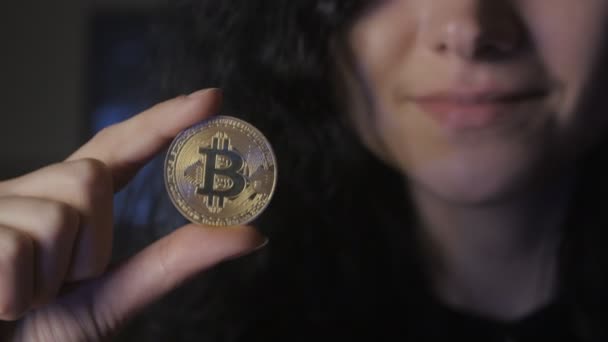 Gros plan de la jeune femme tient Bitcoin d'or dans la main. Mines et commerce — Video