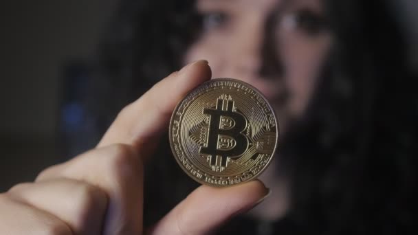 Gros plan de la jeune femme tient Bitcoin d'or dans la main. Mines et commerce — Video