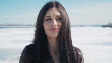 kışın donmuş nehir bir kar arka plan üzerinde genç güzel bir esmer kadın portresi Slowmotion