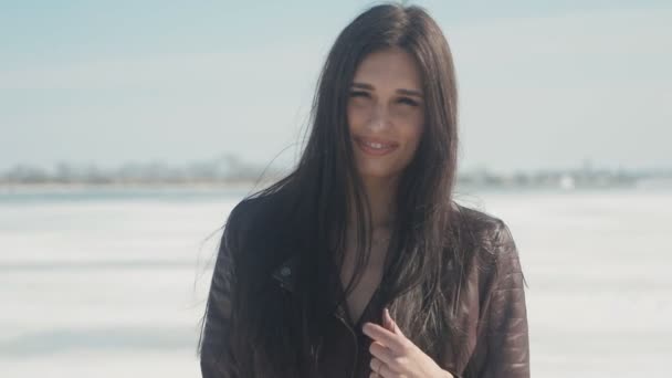 Ralenti portrait de jeune belle femme brune en hiver sur un fond de neige de rivière gelée — Video
