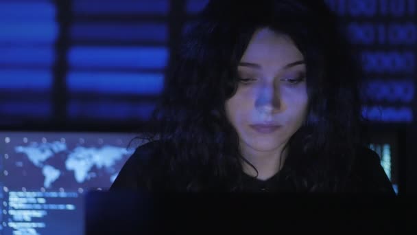 Portrait of young woman programmer working at a computer in the data center filled with display screens — Stock Video