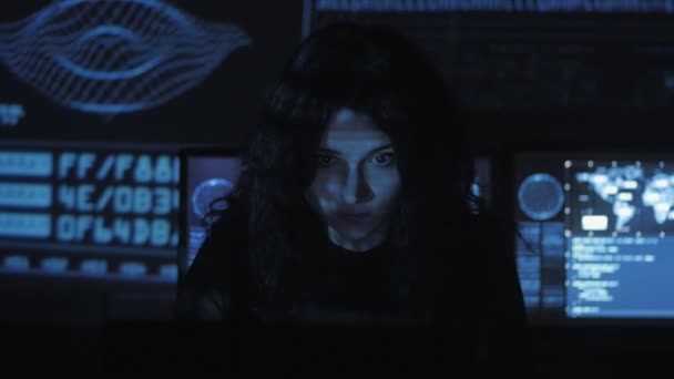 portrait d'une jeune programmeuse travaillant sur un ordinateur dans le centre de données rempli d "écrans d'affichage 