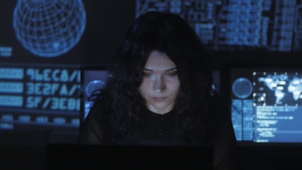 Portrait of young woman programmer working at a computer in the data center filled with display screens — Stock Video