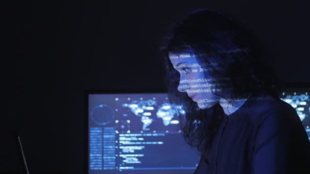 Retrato de una joven programadora que trabaja en una computadora en el centro de datos llena de pantallas — Vídeos de Stock