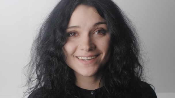 Retrato de mujer sonriente con ojos marrones sobre fondo blanco — Vídeos de Stock