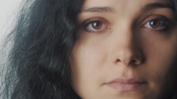 Primer plano retrato de mujer con ojos marrones sobre fondo blanco — Vídeos de Stock