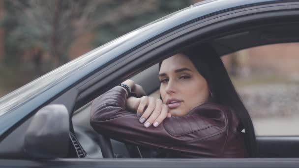 Triste joven sentada en un coche en la ciudad. Chica pensativa esperando en el coche — Vídeos de Stock