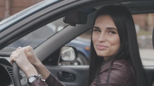 Porträtt av vackra unga kvinna som ler medan sitter bakom ratten i bilen — Stockvideo