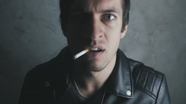 Ağzında sigarayla acımasız agresif bir adam portresi. Tehlike şiddeti