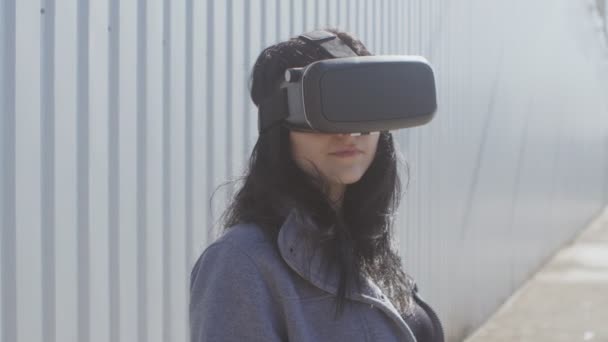 Jovem mulher obtendo experiência em usar VR-fone de ouvido ou fone de ouvido realidade virtual ao ar livre — Vídeo de Stock