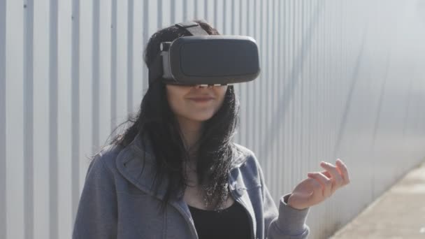 Jeune femme utilisant casque de réalité virtuelle en plein air — Video