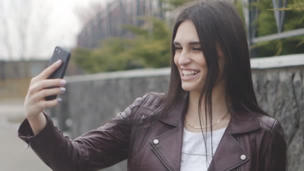 Portrait of cheerful woman doing selfie using her smartphone. — Stock Video